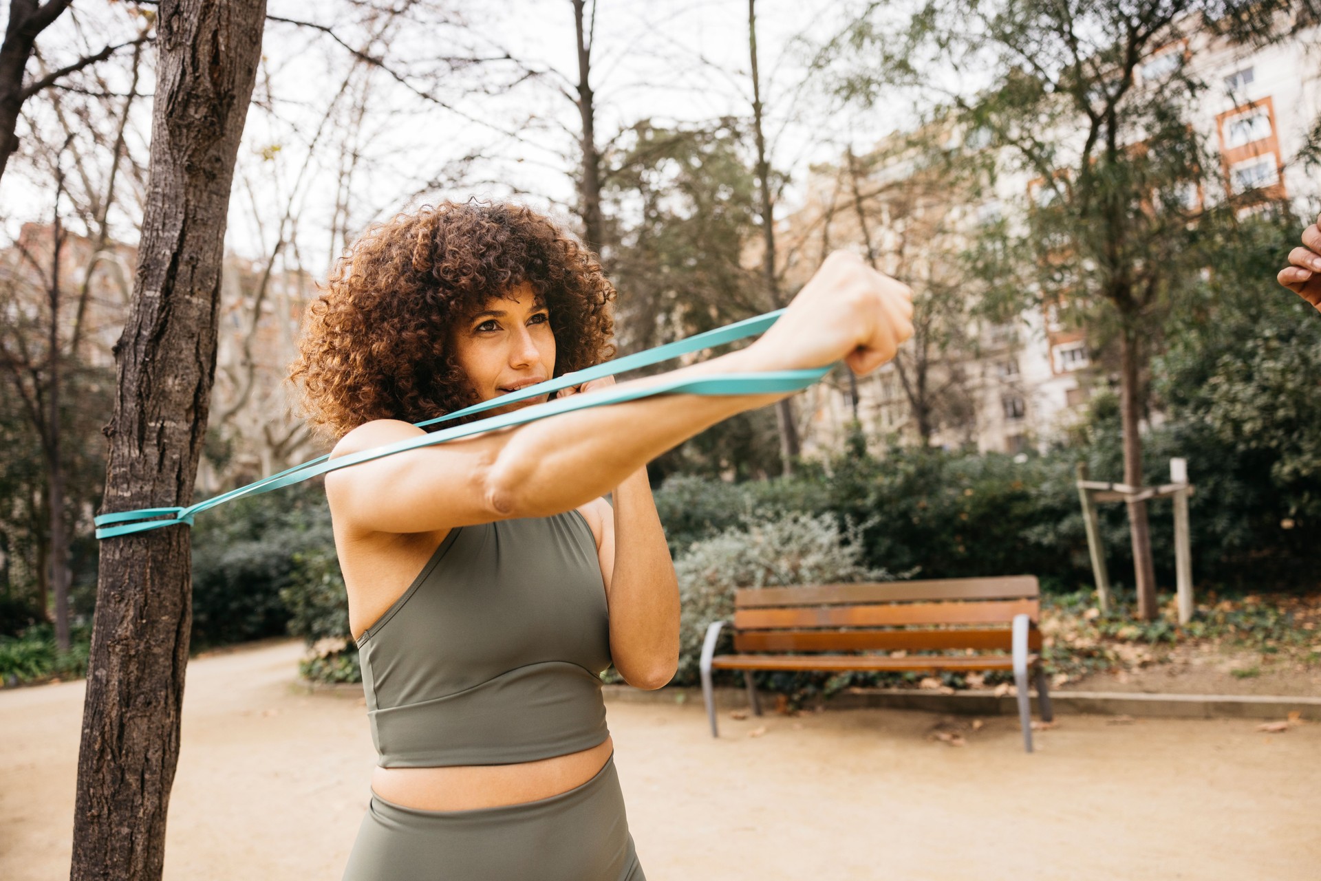 Frau trainiert im Freien mit Gummiband für Krafttraining